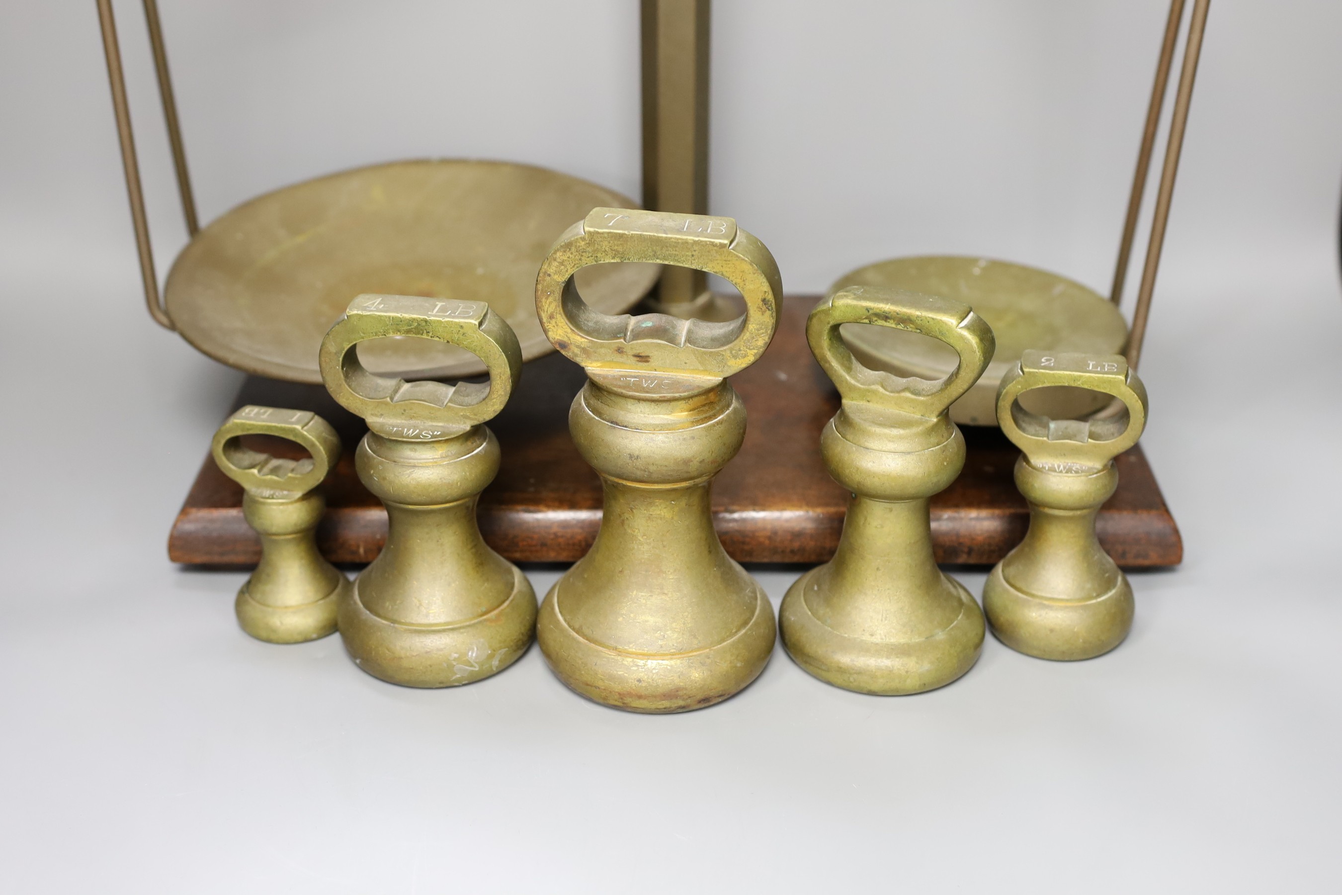 A set of grocer's scales by W&T. Avery Ltd., Birmingham with an 7 LB, two 4 LB, 2 LB and a 1 LB weights